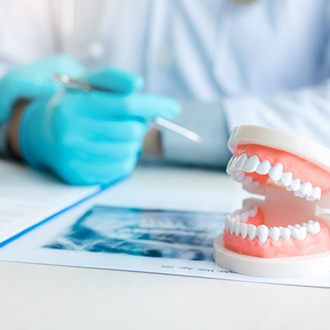 a patient checking her new dentures with a mirror