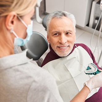 a patient smiling while receiving his new dentures