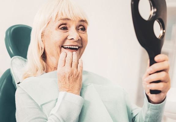 a dentist with a model of dentures on the table